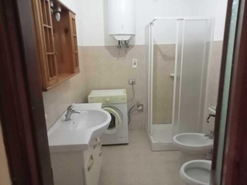 a small bathroom with a sink and a shower at Casa Azzurra 56 in Bova Marina