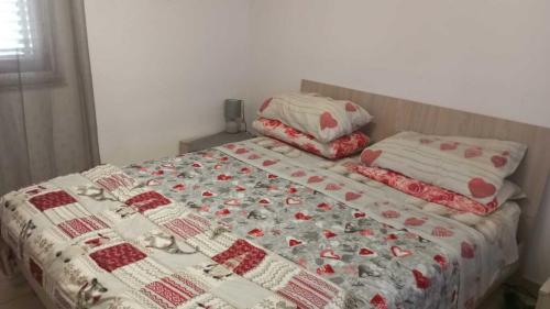 ein Bett mit einer Decke und Kissen darauf in der Unterkunft Casa Azzurra 56 in Bova Marina