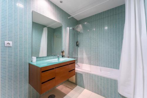 y baño con lavabo, bañera y espejo. en Elegant 2 BDR Flat W/ Rooftop Pool by LovelyStay, en Olhão