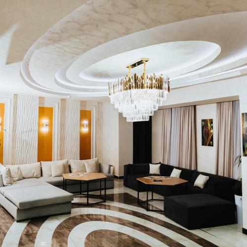 a living room with a couch and a chandelier at Reikartz Namangan in Namangan