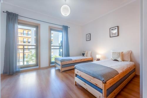 1 dormitorio con 2 camas y ventana en Elegant 2 BDR Flat W/ Rooftop Pool by LovelyStay, en Olhão