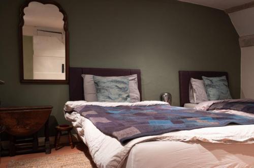 1 dormitorio con 2 camas y espejo en Fishermans Cottage built in 1705, en Hastings
