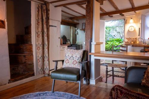 a living room with a chair and a table at Fishermans Cottage built in 1705 in Hastings