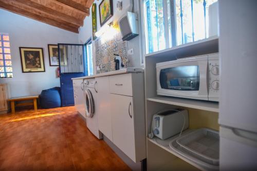 een keuken met een wasmachine, een droger en een magnetron bij la casita de invitados in Los Baños