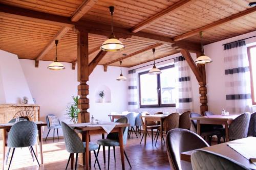 ein Restaurant mit Holzdecken, Tischen und Stühlen in der Unterkunft Pension Lichtenauer Hof in Thyrnau