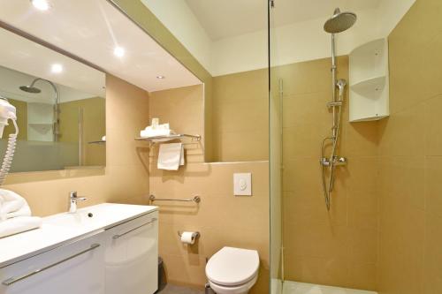 a bathroom with a shower and a toilet and a sink at CALVI APPART HÔTEL in Calvi