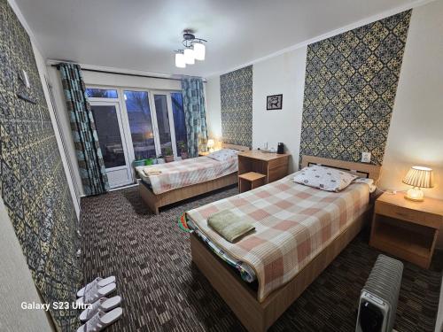 ein Hotelzimmer mit 2 Betten und einem Fenster in der Unterkunft Guest House Mira in Kochkorka