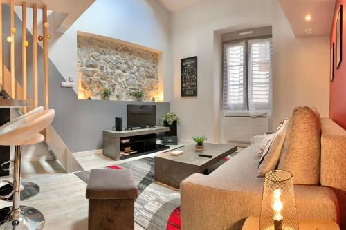 uma sala de estar com um sofá e uma televisão em Chez Margaux T2 Hyper-centre pedestrian street Cosy #C3 em Grenoble