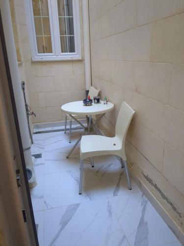 a white table and chairs sitting on a tiled floor at Ta' Stef's Holiday Suites in San Lawrenz