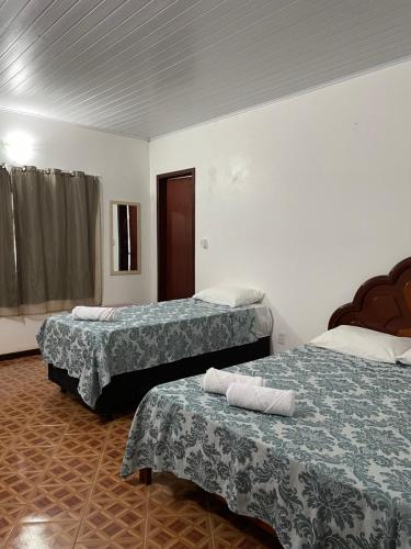 a hotel room with two beds with towels on them at Pousada Recanto dos Sonhos in Alto Paraíso de Goiás