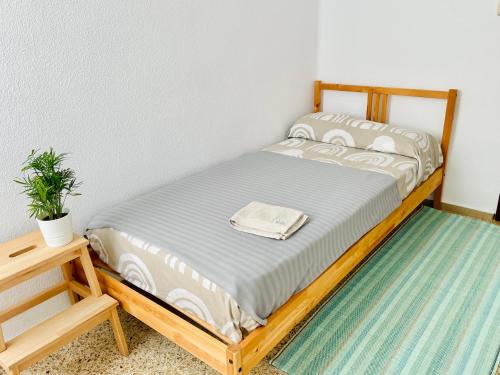 uma cama com uma estrutura de madeira num quarto em Precioso Apartamento de vacaciones playa Valencia Pinedo 2024 em Valência