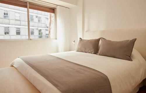 a white bed in a white room with a window at Hestia At Patio Bullrich 1bdr Apartment in Buenos Aires