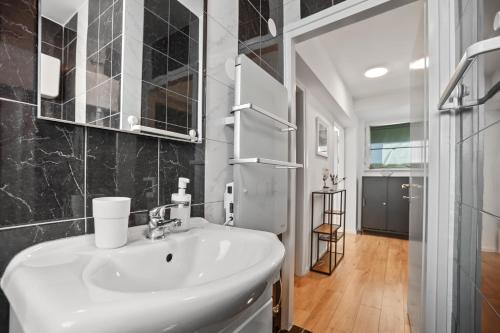 een badkamer met een witte wastafel en een spiegel bij Prime View Apartments Blanca and Lena in Zagreb