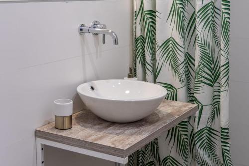 bagno con lavandino bianco e tenda per la doccia di Luxury Suite de Trabuco a Granada