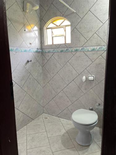 a bathroom with a toilet and a window at Pousada Recanto dos Sonhos in Alto Paraíso de Goiás
