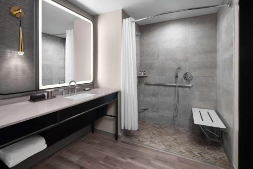 a bathroom with a sink and a shower at Hotel Fraye Nashville, Curio Collection By Hilton in Nashville