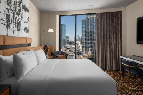 a hotel room with a large bed and a large window at Hotel Fraye Nashville, Curio Collection By Hilton in Nashville