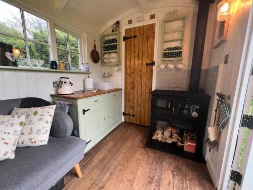 a small kitchen with a stove in a tiny house at shepherd hut glamping in Northumberland in Newcastle upon Tyne