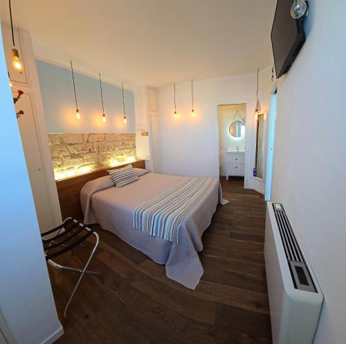 a bedroom with a bed and a tv in it at B&B 106 Maison de Charme in Mola di Bari