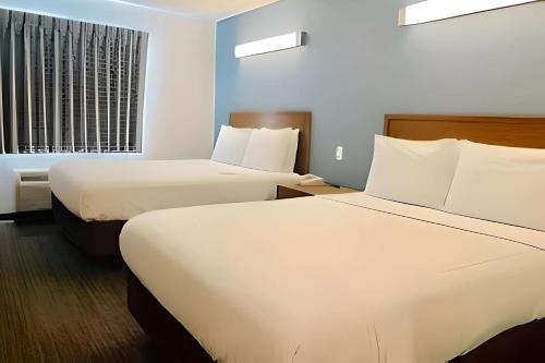 ein Hotelzimmer mit 2 Betten und einem Fenster in der Unterkunft Inn at Rohnert Park in Rohnert Park