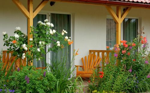 an orange chair sitting on a porch with flowers at Pensiunea Poezii Alese in Valea Drăganului