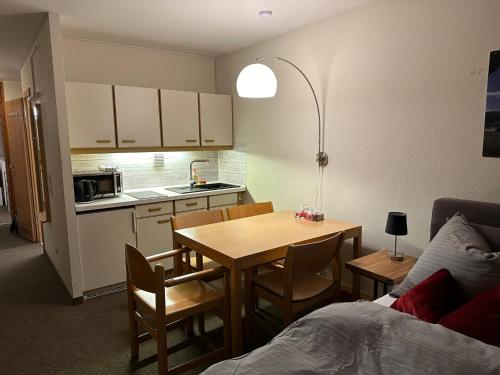 uma pequena cozinha com uma mesa e uma sala de jantar em Pleskini Apartments em Sankt Englmar