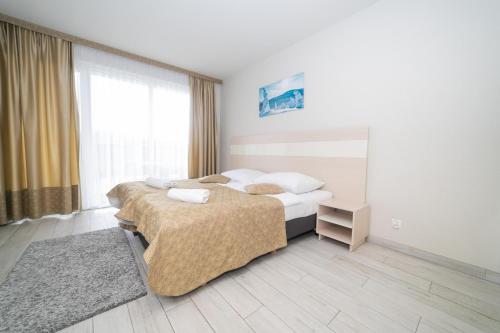 ein Hotelzimmer mit 2 Betten und einem Fenster in der Unterkunft VacationClub - Solden Apartament 33 in Heudorf