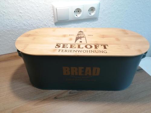 a black container with a wooden top on a table at Ferienwohnung Seeloft in Emden