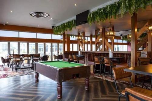 a pool table in a room with tables and chairs at LUXURY CARAVAN 10 mins TO BEACH in Hull