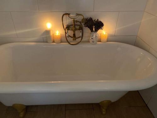 a white bath tub with two candles in a bathroom at Somlói Provence in Doba