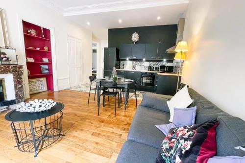 un salon avec un canapé bleu et une cuisine dans l'établissement #H9 Le spacieux de la Gare Large T4 fully equipped Gare de Grenoble, à Grenoble