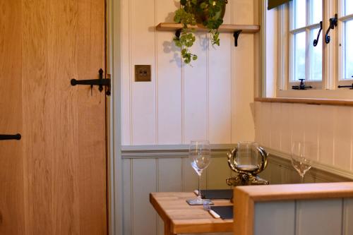 - une cuisine avec deux verres à vin sur une table dans l'établissement The Deer Hut, à Burpham
