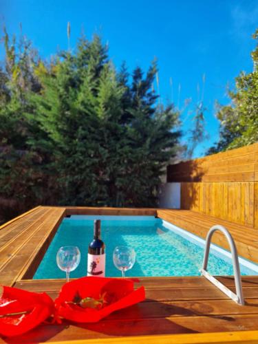 a table with a bottle of wine and glasses next to a swimming pool at Night Flower Villa in Kato Korakiana