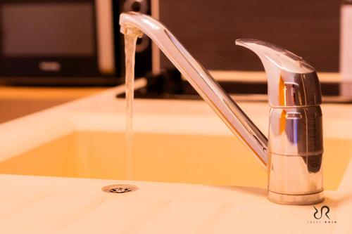 un évier avec de l'eau provenant d'un robinet dans l'établissement Studio Cap d’Agde à 50m du port avec piscine, au Cap d'Agde