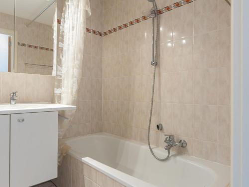 een badkamer met een bad, een wastafel en een douche bij Viking 1 bedroom on floor 5 in Middelkerke