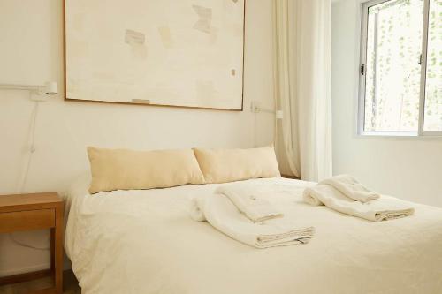 a white bed with two towels on top of it at Hestia At Duhau 2bdr Near Patio Bullrich in Buenos Aires