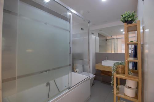uma casa de banho com uma cabina de duche em vidro e um lavatório. em Luxury Apartment With Sea View em Benalmádena