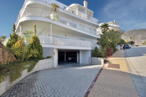 um grande edifício branco com uma garagem ao lado de uma rua em Luxury Apartment With Sea View em Benalmádena