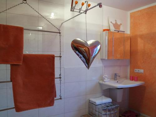 a bathroom with a heart hanging on the wall at Holiday apartment La Maisonannette in Vinningen