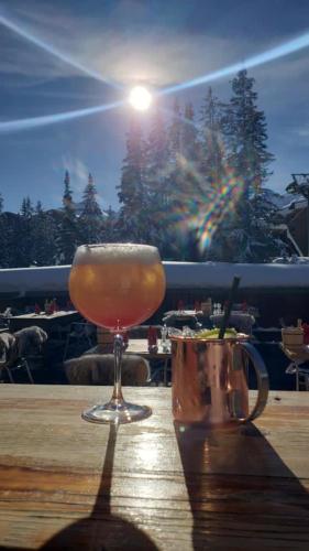 a drink in a glass sitting on a table at Odalys Hotel New Solarium in Courchevel