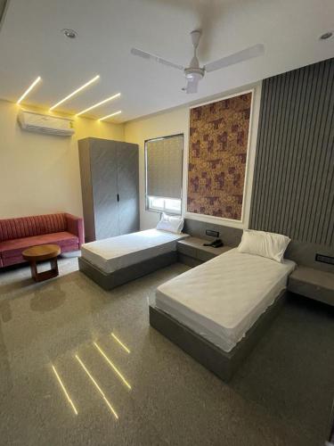 1 dormitorio con 2 camas y sofá en A M Suites en Tohāna