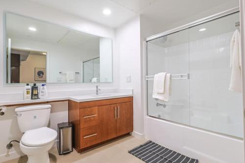 a bathroom with a toilet and a glass shower at Stylish & Cozy 2BDR & 2BTH in SM with Balcony for 6 pax in Los Angeles
