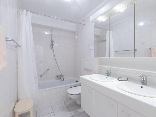 une salle de bain blanche avec un lavabo et des toilettes dans l'établissement Cosy apartment with living room, à Middelkerke