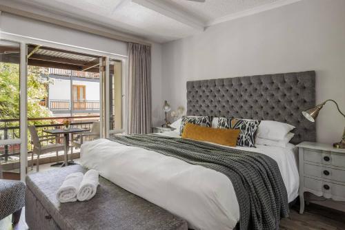 a bedroom with a large bed and a balcony at Casa Bella Stellenbosch - Jan Cats No 4 in Stellenbosch