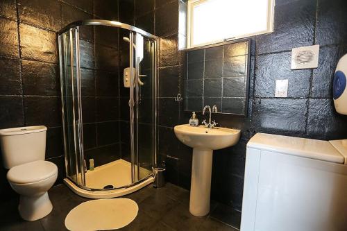 a bathroom with a shower toilet and a sink at Holiday House with garden and sauna in Durness