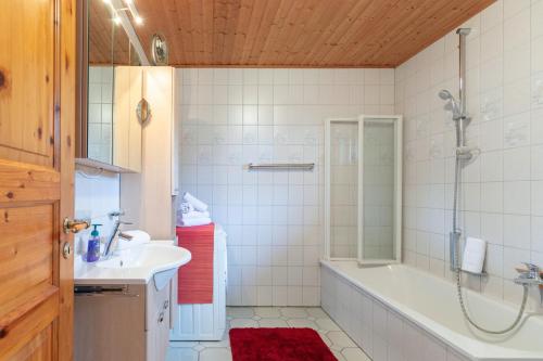 uma casa de banho com uma banheira, um lavatório e um chuveiro em Heidehaus em Enge-Sande