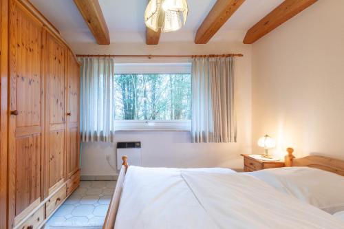 um quarto com uma cama e uma grande janela em Heidehaus em Enge-Sande