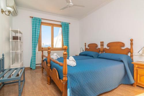 a bedroom with a bed with blue sheets and a window at Can Serra 4 -Santa Margalida- in Santa Margalida
