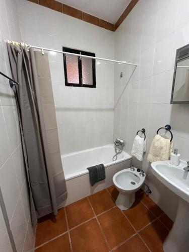 a bathroom with a tub and a toilet and a sink at Casa Tita Maria in Trevélez