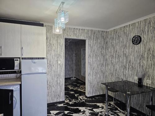 a kitchen with a white refrigerator and a table at Apartment in City Center, street Banulescu Bodoni 57 in Chişinău